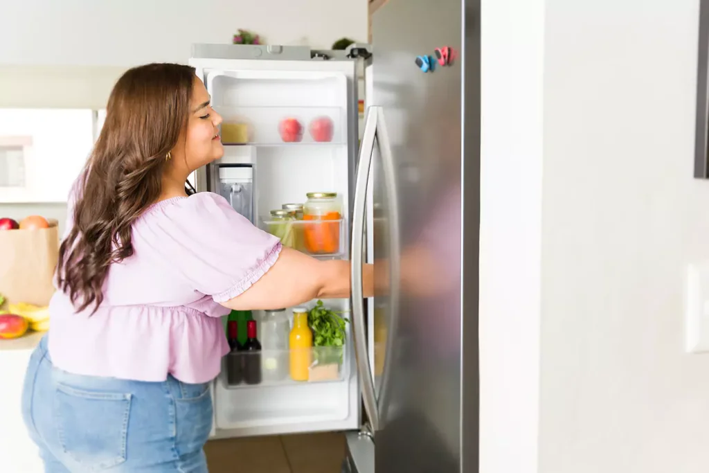 A girl looking inside the refrigerator