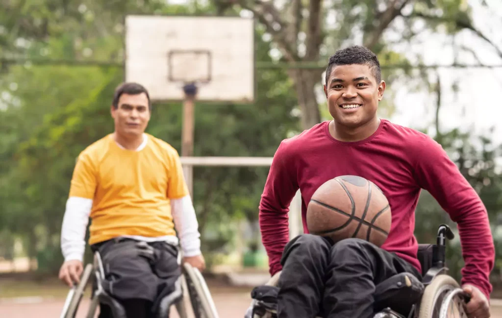 Two disabled man sitting in their wheelchair playing basketabll