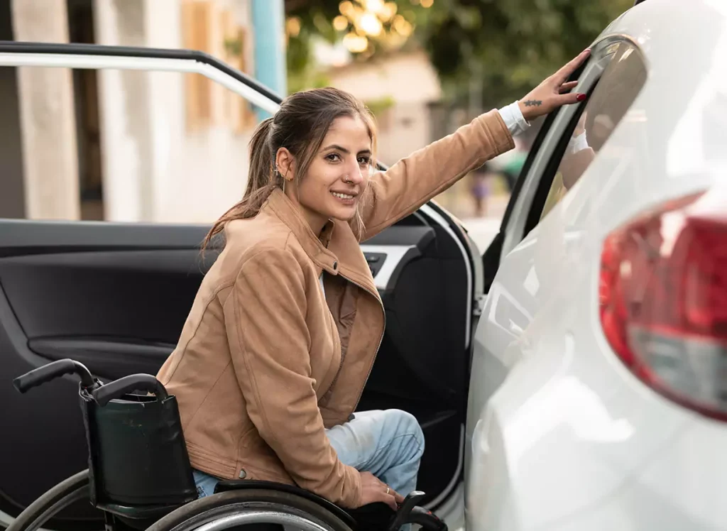 A disabled woman sitting in her wheelchair holding her car