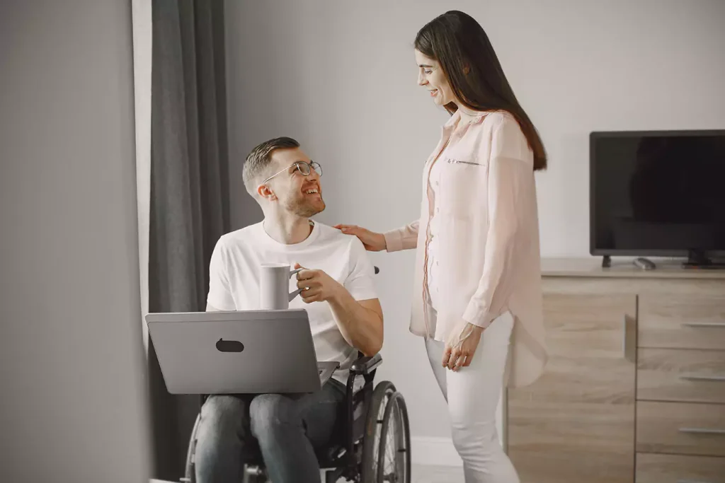 A disabled man sitting in his wheelchair and his support worker