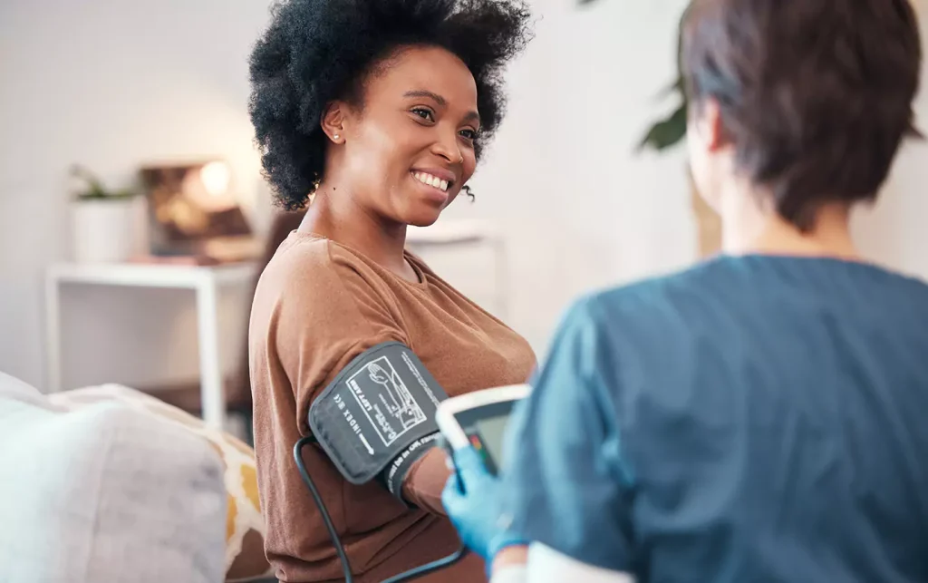 A disabled woman and a nurse getting her blood pressure